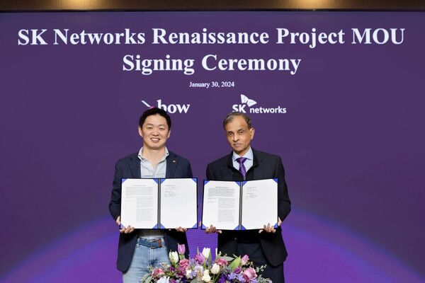SK networks President and Chief Operating Officer Choi Sung-hwan (left) and Vivek Ranadive (right), the founder and chairman of Bow Capital, pose with signed copies of a memorandum of understanding between their two companies at a ceremony held at the Samil Building in the Jongno district of Seoul on Jan. 31.