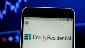 An image of a stock chart in the background of a phone cropped to show the Equity Residential (EQR) logo