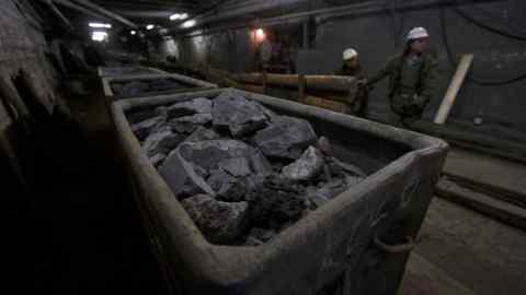 Rail trucks being loads with rocks containing uranium ore