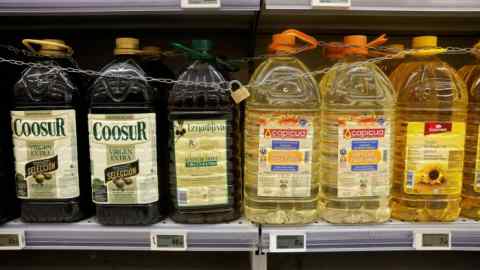 Bottles of olive oil and sunflower oil on a grocery shelf
